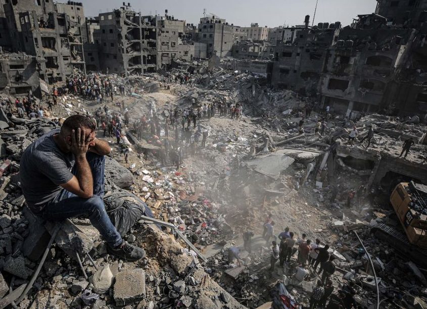 Image from CNN, man sits on the rubble of former neighborhood in Gaza as Palestinians search and attempt to rescue those bombarded by Israeli missiles in Gaza on November 1.