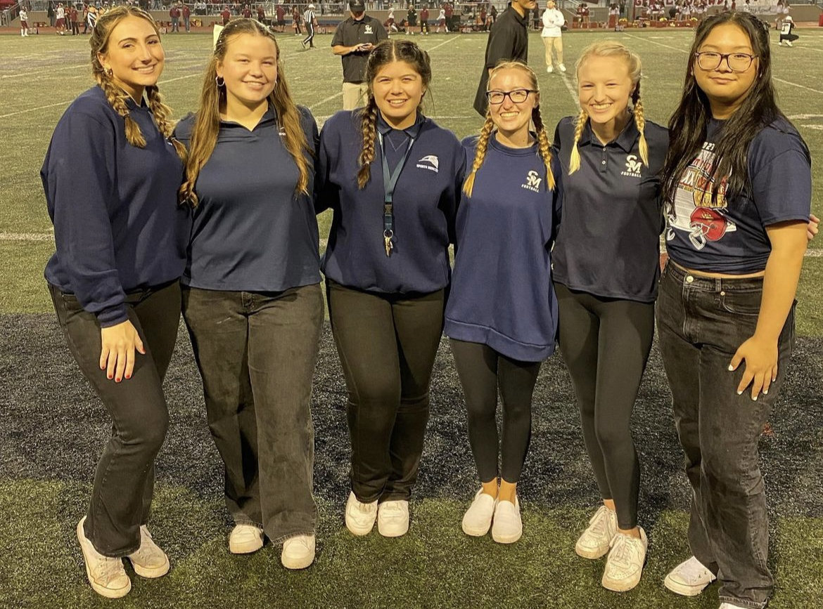 Athletic trainers at a SMHS football game on the sidelines. Senior trainer Juliet Martin to the far left followed by senior trainers Kristen Patt and Elizabeth Allen to her immediate right.